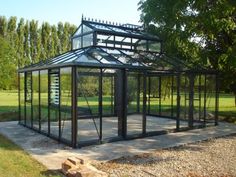 a glass house sitting in the middle of a park