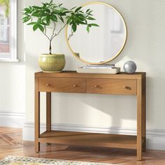 a wooden table topped with a mirror and a potted plant on top of it