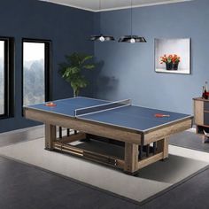 a ping pong table in the middle of a room with blue walls and windows