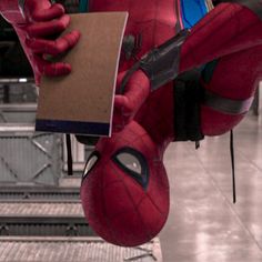 spider - man holding a clipboard in his right hand