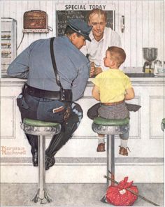 a man sitting at a counter with a little boy in front of him and an older man standing next to him