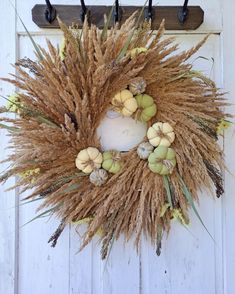 a wreath hanging on the side of a door decorated with dried flowers and leaves,