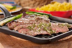 steak and vegetables on a grill pan with tongs