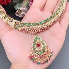 Featuring a traditional jadau necklace embellished with fine quality rubies, emeralds and pearls. This handcrafted piece of luxury has been crafted in 22ct gold. The necklace weighs 32.14 GMs including 1.29 GMs of hanging ruby emerald beads. The earrings weigh 22.87 GMs including3.4 GMs of ruby emerald beads. The intricate detailing perfectly complements traditional Indian attire, designed to be admired for generations to come. It's an exquisite representation of Indian culture and heritage. Green Ruby Necklace For Celebrations, Traditional Green Emerald Necklace In 22k Gold, Traditional Gold Emerald Necklaces, Gold Emerald Chandbali Necklace, Traditional Emerald Kundan Necklace Hand Set, Traditional Kundan Necklace With Emerald, Traditional Emerald Kundan Necklace, Traditional Round Emerald Necklace, Traditional Festive Emerald Gemstone Necklace