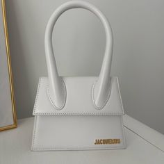 *Real* Currently Selling For $900 On Their Website White Le Chiquito Moyen Jacquemus Bag Includes Dust Bag And Shoulder Strap I Do Not Have The Box Included Email I Received When Purchased From Jacquemus Website I Only Wore It One Time No Stains Or Damage Brand New Condition Will Accept Offers Close To Asking Price Le Chiquito Moyen, Jacquemus Bags, Jacquemus Bag, Woven Raffia, Distressed Black Jeans, One Time, Shop Wallpaper, Crate And Barrel, White Leather