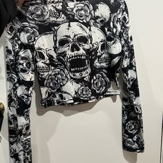 a black and white shirt with skulls on it is hanging from the wall next to other items