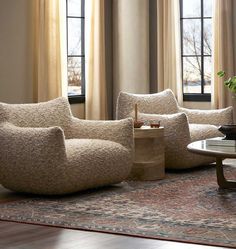 a living room with couches, chairs and a coffee table in front of two windows