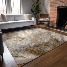 a living room with a couch, chair and rug in front of a fire place