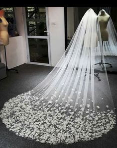 a wedding veil with white flowers on it