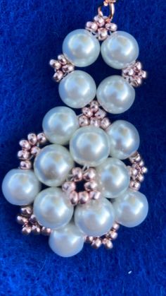 a necklace with pearls and gold beads on a blue background