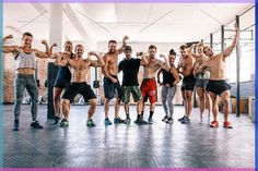 a group of men standing in a gym posing for the camera with their arms up