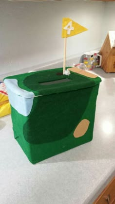 a green box with a flag sticking out of it sitting on a kitchen counter top