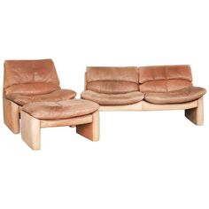 two couches and a footstool sitting next to each other on a white background