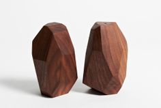 two wooden objects sitting side by side on a white surface