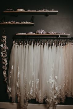 wedding dress hanging on the wall in front of two shelves