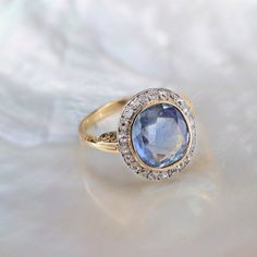 a ring with a blue stone surrounded by diamonds