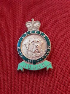 a badge with a dog on it sitting on a red cloth