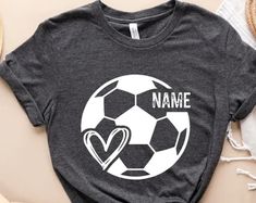 a t - shirt that says name with a soccer ball in the center and hearts on it