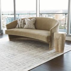 a couch with two pillows on top of it in front of a large glass window