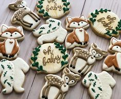 many decorated cookies with animals and words on them sitting on a wooden table next to each other