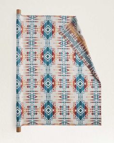 an orange, blue and white patterned cloth with a wooden stick sticking out of it