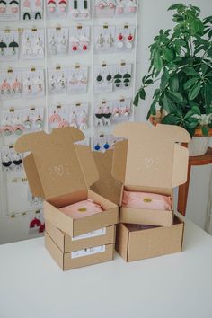 two open boxes sitting on top of a table next to a potted green plant