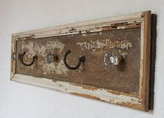 an old wooden coat rack with four knobs and three hooks on the front wall