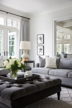 a living room filled with lots of furniture and flowers on top of a coffee table