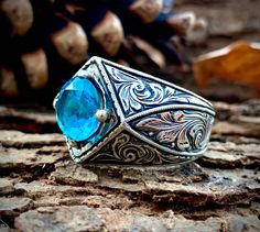 a blue stone ring sitting on top of a rock