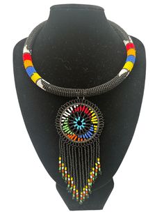 Add a unique touch to your jewellery collection with this authentic African black beaded tassel ethnic pendant necklace. The necklace features a beautifully crafted tassel pendant. The pendant is strung on a beaded necklace that complements the pendant's design. This necklace is perfect for those who love ethnic and regional styles. It is an ideal accessory to wear with a simple outfit to add a pop of colour and unique flair.   Neck Width - 18 inches. Colour: Black Material: Beads, Brass Artisan Black Bead Dangle Jewelry, Bohemian Jewelry With Black Beads, Bohemian Jewelry With Black Round Beads, Artisan Black Beaded Chain Jewelry, Artisan Black Beaded Dangle Jewelry, Bohemian Jewelry With Black Beads, Round Shape, Black Artisan Beaded Chain Jewelry, Traditional Dangle Necklaces With Colorful Beads, Artisan Black Beads Dangle Jewelry