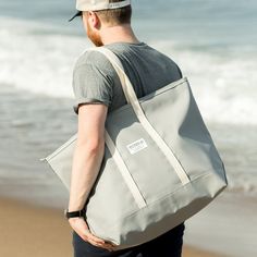 Step out in style with our stunning Grey Steeletex Zip Top Beach Tote. Crafted from durable vinyl, this chic tote is both water and tear-resistant, ensuring it stays pristine with minimal effort. The elegant 10" handle drop allows you to carry it over your shoulder effortlessly, freeing your hands, so you can do things like sending quick texts and enjoying your coffee. Featuring a zippered top and an interior pocket, this tote keeps your essentials secure and organized, making it the perfect acc Sea Colour, Beach Tops, Beach Tote, Zip Top, You Can Do, Texts, Shades, Tote Bag, Vinyl