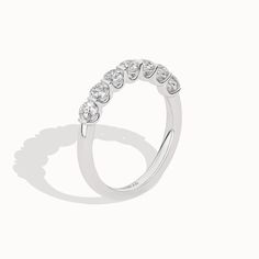 The 7-Stone Keepsake Vows ring is a beautiful representation of love and commitment. With seven round diamonds set in a stunning gold/platinum band, this ring captures the essence of everlasting love. Its exquisite design and flawless craftsmanship make it a cherished piece for a lifetime. Timeless Half Eternity Cubic Zirconia Diamond Ring, Elegant Moissanite Half Eternity Ring, Timeless White Gold Halo Ring With Round Band, Timeless White Gold Halo Ring, Timeless Oval Half Eternity Diamond Ring, Timeless Stackable Rings With Prong Setting, Timeless 14k White Gold Round Diamond Ring, Dazzling Half Eternity Diamond Ring With Round Band, Timeless Round Cut Halo Ring For Anniversary