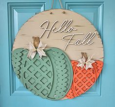 a wooden sign that says hello fall and two pumpkins on the front of it