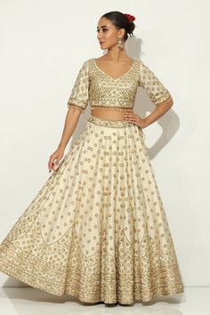 Ivory and gold kalidar lehenga with all over Padma bagh motif embroidery using zardozi highlights and tassel ornamentation. Paired with an elbow sleeves floral jaal embroidered leaf neck blouse with dangling glass beads hem and a bloom border embroidered dupatta. - Aza Fashions Beige Embroidered Reception Set, Cream Sets With Resham Embroidery For Reception, Elegant Raw Silk Lehenga With Gota Work, Elegant Lehenga With Gota Work In Raw Silk, Elegant Beige Choli With Intricate Embroidery, Elegant Embroidered Cream Lehenga, Elegant Cream Choli For Festive Occasions, Elegant Cream Choli For Festive Season, Ceremonial Off White Sets With Resham Embroidery