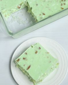 a piece of green cake sitting on top of a white plate next to a pan