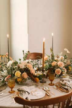 the table is set with flowers and candles