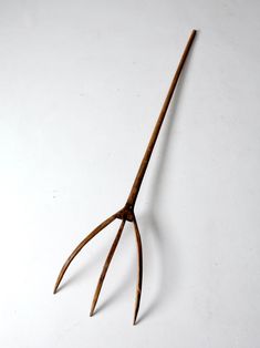 an old pair of scissors on a white surface with long, thin blades sticking out of it