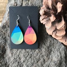 "\"GEOMETRIC RAINBOW PRINT TEARDROP DANGLE EARRINGS\" Made out of up-cycled wood, with a sublimated abstract rainbow.  The earrings have a geometric print, with red, orange, yellow, green, blue, and purple, aka rainbow colors.   Pattern placement will vary on each design; meaning placement of geometric colors will vary greatly on each earring set. Approximate Dimensions: 1 1/2\" X 1\" (without drop) 2 3/8\" X 1\" (with drop) Materials: Upcycled Wood Hypoallergenic Stainless Steel Earring Hook Fa Casual Multicolor Teardrop Earrings, Cheap Multicolor Teardrop Earrings, Cheap Rainbow Teardrop Earrings, Vibrant Multicolor Dangle Earrings, Multicolor Resin Teardrop Earrings, Geometric Rainbow, How To Clean Earrings, Upcycled Wood, Hand Balm