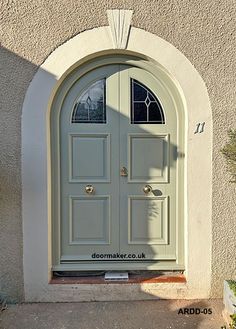 an arched door with two windows on the side of a building