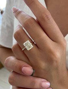 a woman's hand with a diamond ring on it