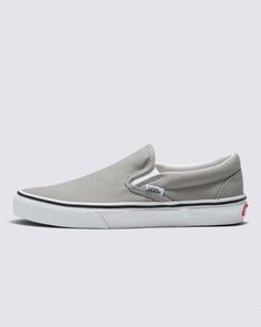 Introduced in 1977, the Vans #98, now known as the Classic Slip-On is a Southern California icon and everyday essential. This Drizzle/True White Classic Slip-On Shoe includes a low profile canvas upper, supportive padded collar, elastic side accent, and out signature rubber waffle outsoles. Classic Vans Slip-on Sneakers, Classic Vans Slip-on Sneakers With Round Toe, Classic Round Toe Slip-ons For Streetwear, Classic Gray Slip-on Sneakers, White Shoe, Vans Classic Slip On, Vans Classic, White Shoes, Southern California