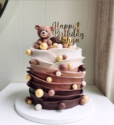 a birthday cake with a teddy bear on top