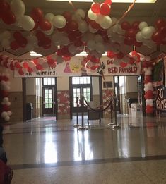 an empty hall with balloons and banners hanging from the ceiling