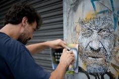 a man is painting on the side of a building