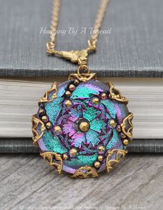 A lovely necklace made using a very ornately detailed vintage glass button. I just love all the detail in this button and the super reflective, colorful finish!  It has a shimmery electra style finish with purples, greens, gold and more! I've set the button in a large, golden brass filigree stamping and hangs from a filigree style connector. The entire pendant measures 1 3/8" around and 2" long, including the bail. The pendant hangs from gold plated chain. Please choose desired length at checkout. Truly a unique and stunning piece! Makes a wonderful gift for any button lover, seamstress, or the person who loves unique things! Vintage Glass Necklace Nickel Free, Vintage Nickel-free Glass Necklace, Vintage Glass Nickel-free Necklace, Unique Cabochon Necklaces For Wedding, Vintage Glass Jewelry For Weddings, Antique Glass Jewelry For Gifts, Antique Glass Jewelry As Gift, Vintage Czech Glass Jewelry For Gift, Unique Medallion Necklace For Wedding