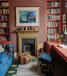 a living room filled with furniture and bookshelves next to a fire place under a painting