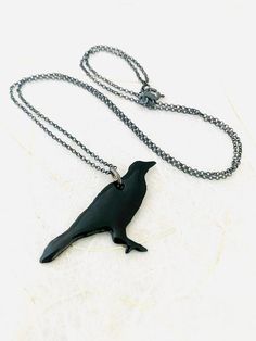 Crow Necklace - Dark Gray Enamel Bird NecklaceGray enamel fused to copper. Includes 18 inch Sterling silver chain. Swallow measures 1 1/4 inch in height 1 inch in width. Handle as glass Handmade in The Pacific Northwest 🐦 Crow Necklace, Crow Pendant, Black Crow, Bird Necklace, Bird Pendant, Bird Earrings, Bird Jewelry, The Pacific Northwest, Earrings Photo