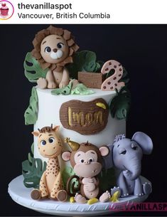 there is a cake decorated with animals and letters on the bottom layer, along with leaves