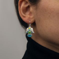 Introducing our Handcrafted Love Angel Earrings, the perfect embodiment of divine elegance, ideal for gifting that special someone or treating yourself to a touch of heavenly charm. These earrings are meticulously crafted with sterling silver and adorned with the vibrant allure of Cloisonné Enamel. The unique technique used in their creation breathes life into the design, making each pair truly unique. A testament to high-quality craftsmanship, the earrings are made from 925 sterling silver, ensuring durability and long-lasting shine. Key Features: - Handmade Love Angel Earrings - Compact size, measuring just 0.8 inches (2cm) long - Crafted from premium 925 Sterling Silver - Adorned with radiant Cloisonné Enamel - Arrives in a beautiful, branded gift box These earrings don't just make a st Elegant Sterling Silver Jewelry With Artistic Design, Enamel Pendant Earrings For Gifts, Enamel Jewelry For Pierced Ears As A Gift, Artistic Dangle Jewelry As Gift, Artistic Dangle Jewelry For Gifts, Artistic Design Dangle Jewelry Gift, Enamel Drop Earrings As A Gift, Enamel Drop Earrings For Gifts, Symbolic Drop Earrings Jewelry As Gift