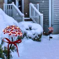 christmas lights are lit up in front of a house with snow on the ground and trees